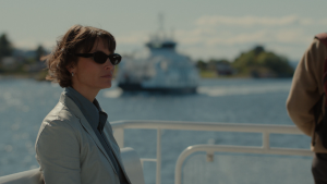Woman standing on a boat with black sunglasses 