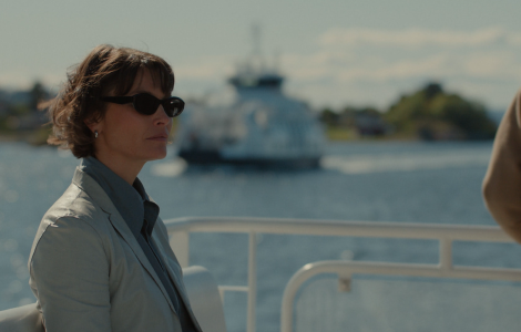 Woman standing on a boat with black sunglasses